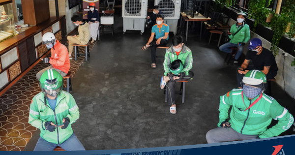 Không chỉ giao hàng, trong khi lấy đồ các shipper cũng giữ khoảng cách an toàn với nhau để tránh lây nhiễm COVID-19.