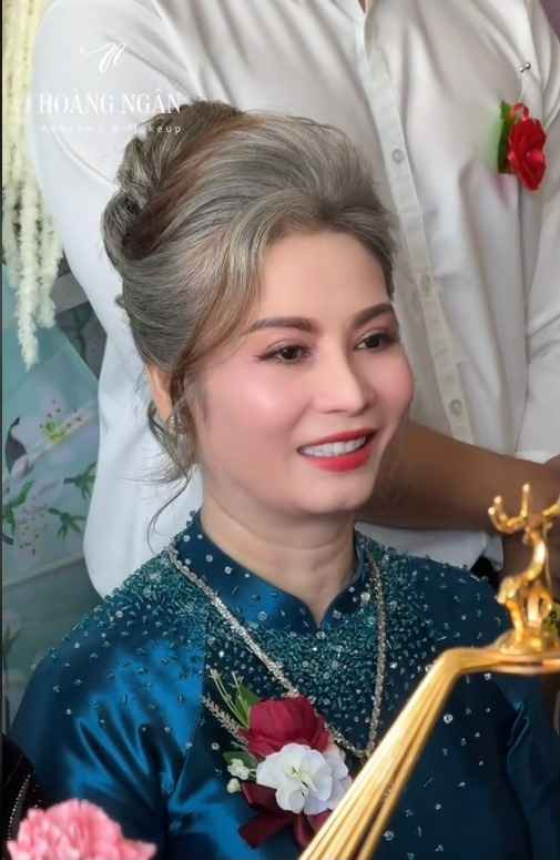 Theo đội make up chia sẻ, mái tóc của mẹ chú rể là bạc tự nhiên, không nhuộm. Bà chủ tiệm vàng cũng chọn layout make up nhẹ nhàng cũng mái tóc búi sang trọng để đi hỏi vợ cho con trai.