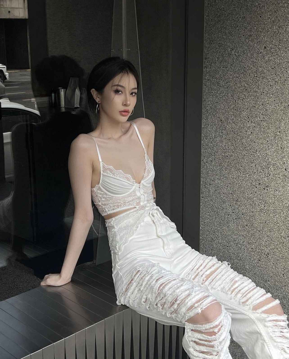 Người đẹp 10X mặc cả “cây trắng” với quần jeans cạp cao rách trải dọc thân, áo ren corset cúp ngực hớ hênh.