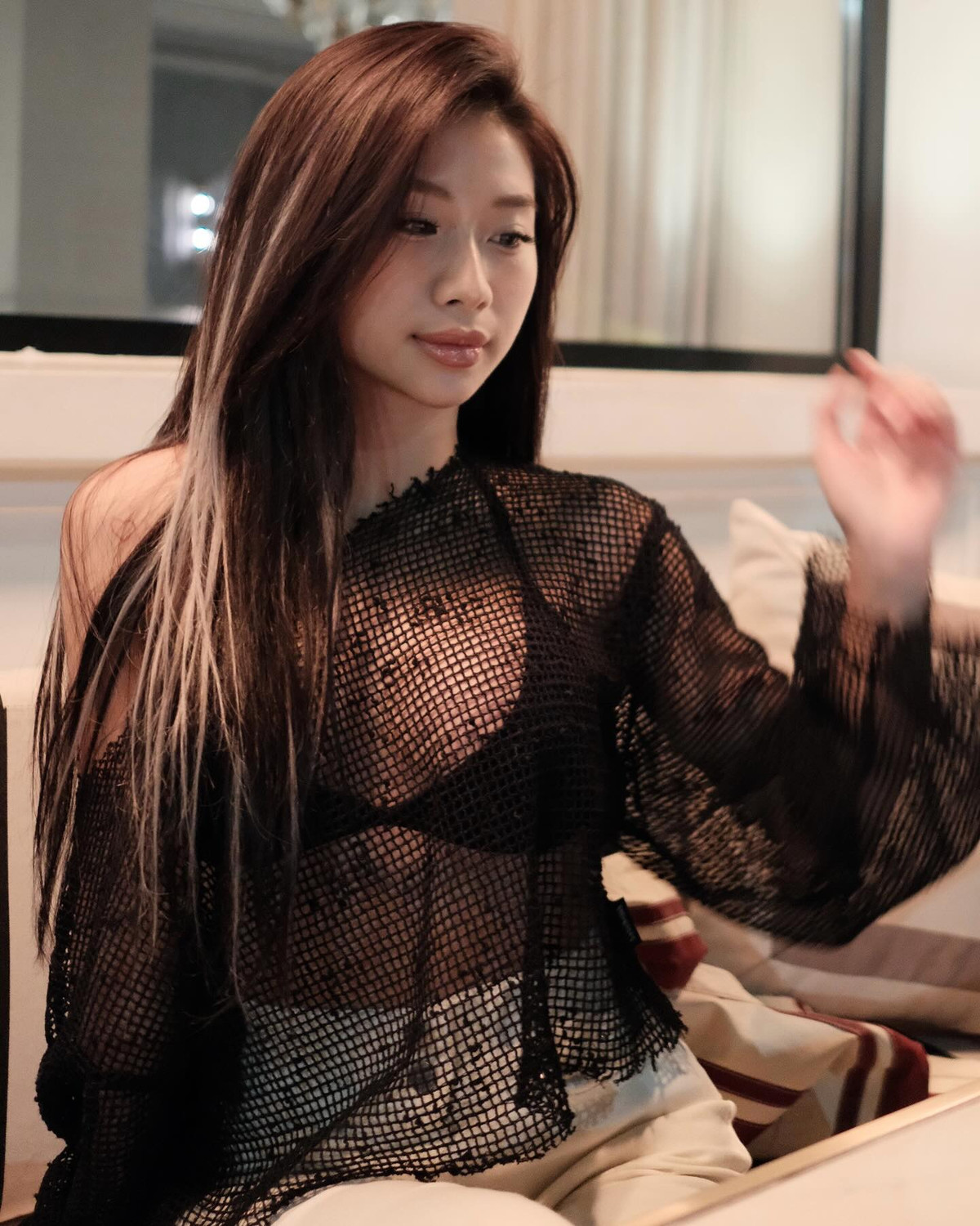 Louis Phạm diện áo lưới tay dài, trễ vai khoác bên ngoài, lấp ló bên trong là chiếc bra đen giúp nữ TikToker khoe vòng 1 căng đầy - thành quả của phẫu thuật thời gian gần đây.