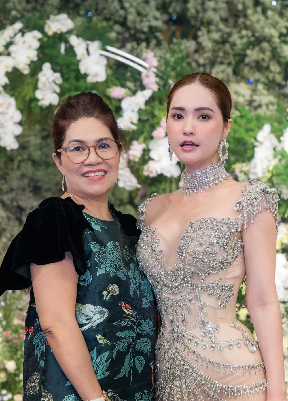 Ngoài visual tỏa sáng của nữ đại gia netizen còn ngạc nhiên với diện mạo của hai bậc phụ huynh. Mẹ chồng người đẹp diện đầm trễ vai, kết hợp vòng cổ kim cương vô cùng quý phái.