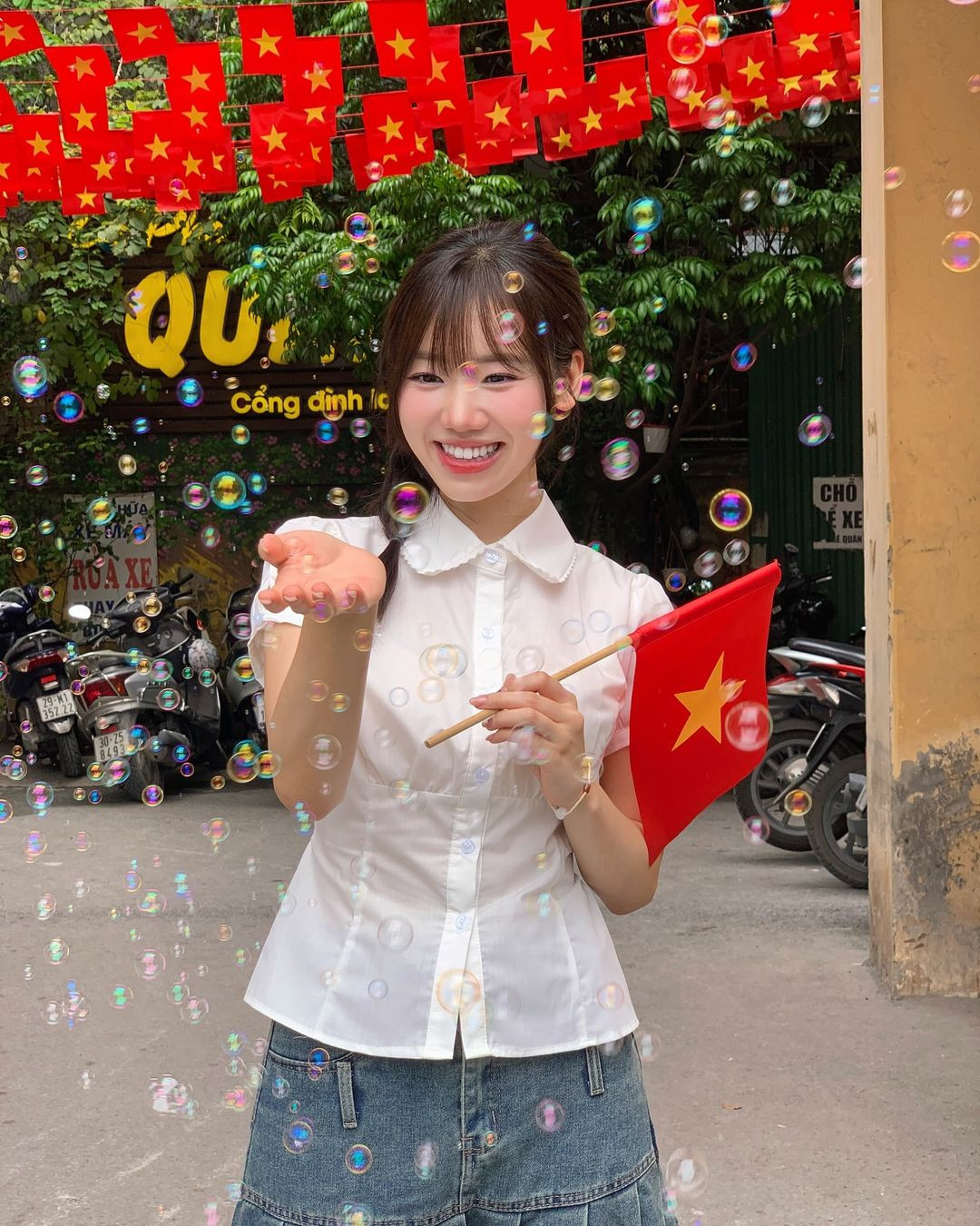 Mei Chan khoe chuẩn nàng thơ khi chụp ảnh dưới con đường làng rợp bóng cờ.