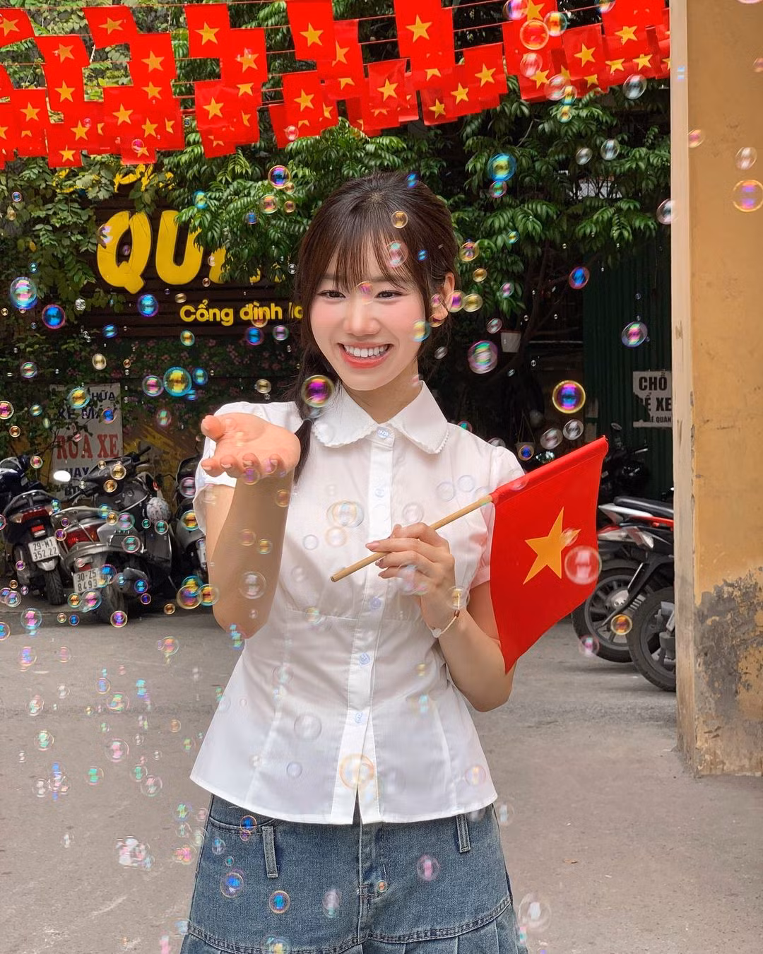 Mei Chan khoe chuẩn nàng thơ khi chụp ảnh dưới con đường làng rợp bóng cờ.