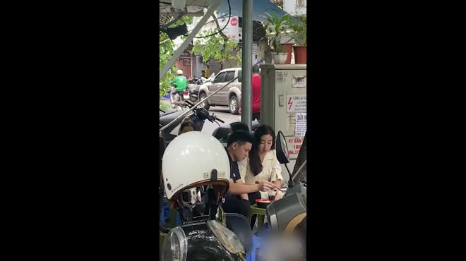 Cặp đôi ngồi tại một quán chè vỉa hè trên phố Hàng Gai, Hà Nội. Cả hai ăn mặc giản dị, ngồi sát nhau và liên tục trò chuyện.