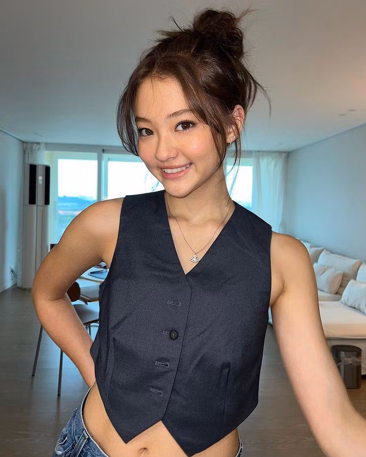 Để tạo điểm nhấn cho outfit, "bé gái lai xinh đẹp nhất thế giới" mix với dây chuyền sợi mảnh và khuyên tai đồng điệu. Ella Gross sử dụng tông make up nhẹ nhàng và tóc búi gọn để giúp làm nổi bật đường nét trên gương mặt.