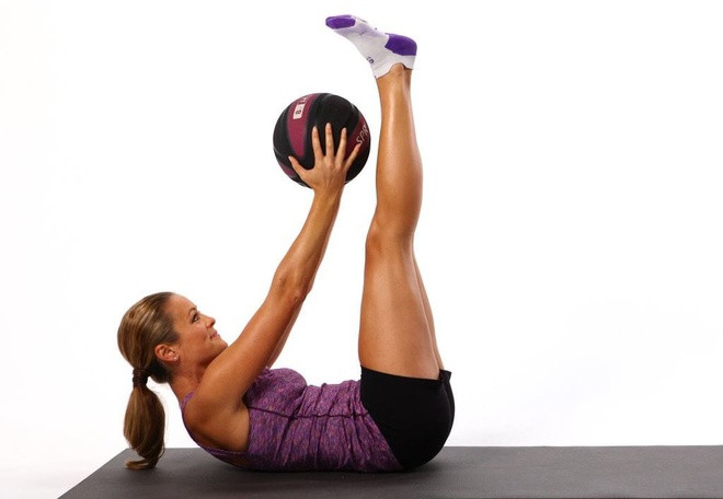 Nằm ngửa nâng cao tay chân: Bài tập này sẽ giúp cơ bụng trên săn chắc. Bạn có thể thực hiện với tạ hoặc bóng để tăng độ khó cho động tác. Cách thực hiện: Nằm ngửa, giơ 2 chân lên cao một góc 90 độ so với mặt sàn. Cánh tay giơ thẳng, đồng thời hơi nhấc vai và lưng lên khỏi sàn. Giữ một giây, sau đó, từ từ hạ thấp vai và trở về vị trí ban đầu. Luôn giữ thẳng tay và chân trong khi thực hiện. Ảnh: Verywellfit.