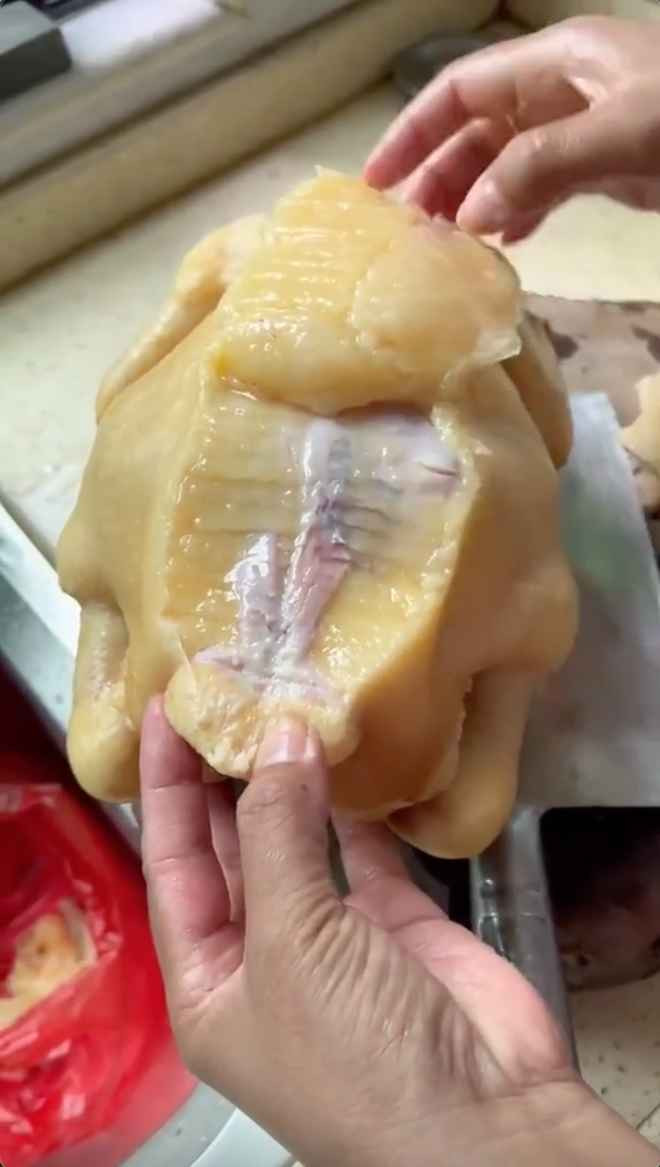 Dù mới là nhát dao đầu tiên nhưng thân hình con gà luộc này đã hé lộ... 90% là mỡ vàng ươm.