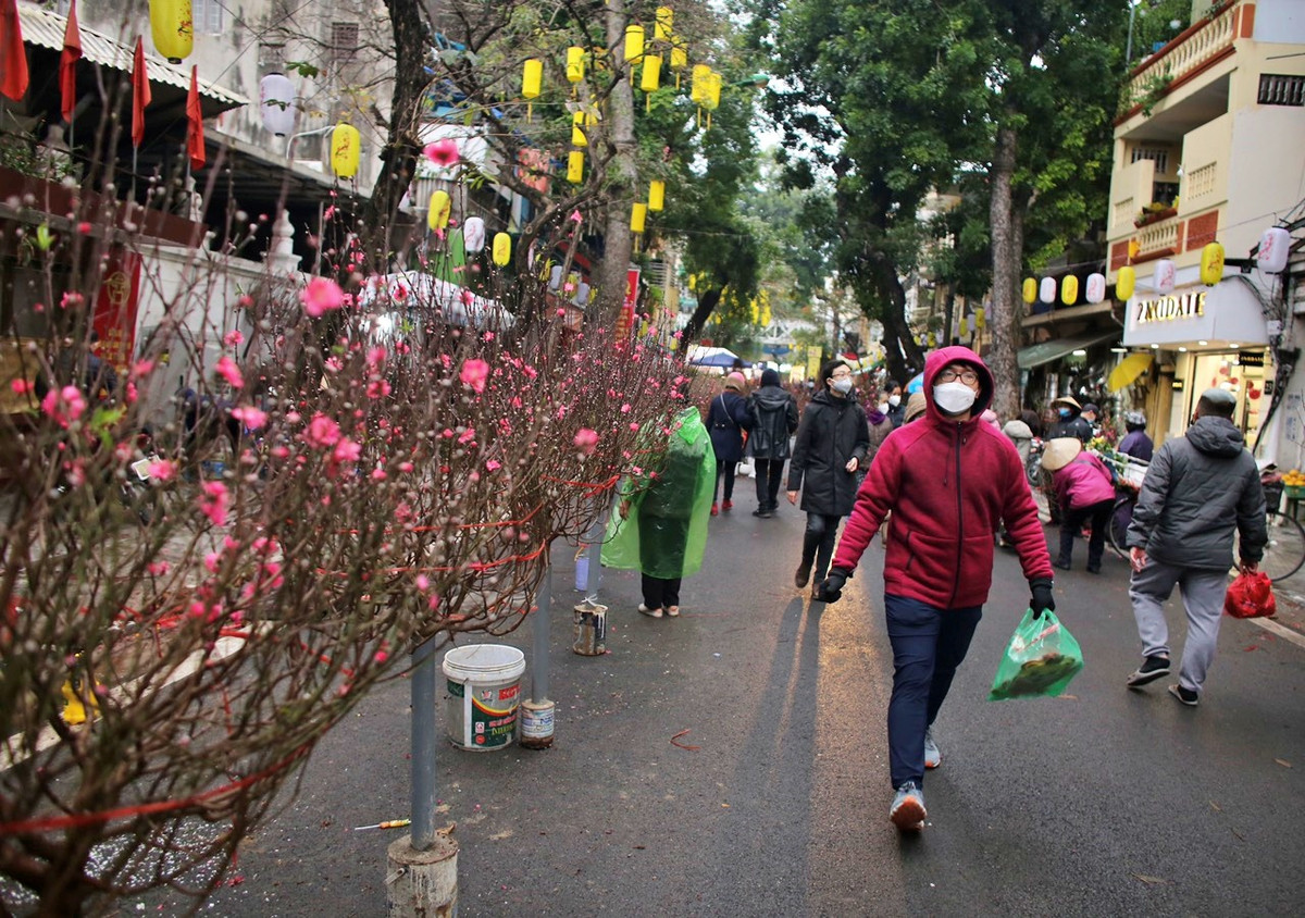 Ngoài nhu cầu mua sắm, nhiều người trẻ diện trang phục áo dài và chụp ảnh tại những cửa hàng được trang trí rực rỡ, mang đậm sắc Tết.