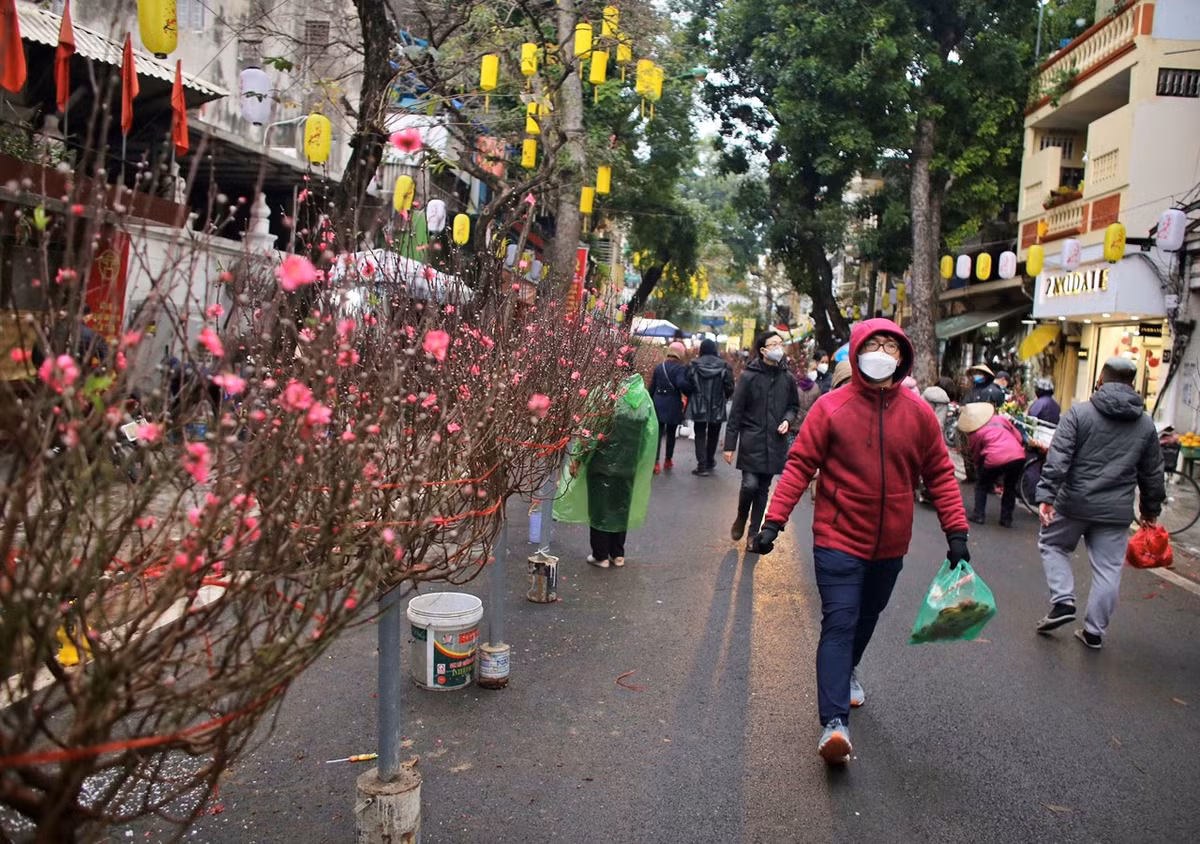 Ngoài nhu cầu mua sắm, nhiều người trẻ diện trang phục áo dài và chụp ảnh tại những cửa hàng được trang trí rực rỡ, mang đậm sắc Tết.