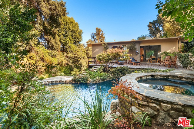 Hồ bơi và bồn tắm nước nóng ngoài trời được thiết kế với thành đá độc đáo.