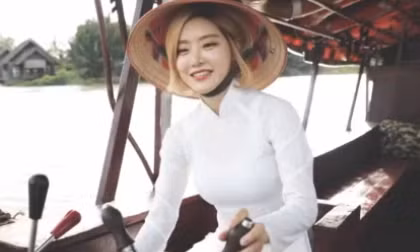 DJ Soda chọn chiếc áo dài trắng dáng truyền thống, chiết eo nhẹ nhàng. Họa tiết hoa sen với sắc hồng, xanh trang nhã.