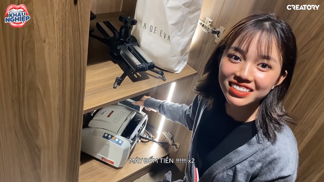 Trước đó trong một clip tham quan nhà mới của Độ Mixi được Linh Ngọc Đàm đăng tải, nữ streamer đã vô tình phát hiện một chiếc máy "lạ" và hỏi đàn anh có phải là máy đếm tiền không thì "tộc trưởng" bối rối trả lời đó chỉ là máy đếm tài liệu.
