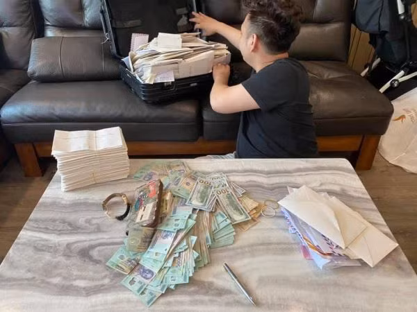 Tiền mừng sau đám cưới của Xemesis và bà xã Xoài Non có đủ từ tiền Việt tới ngoại tệ. Những tờ tiền mệnh giá 500.000 đồng được xếp thành cả cọc, còn chàng streamer giàu nhất Việt Nam thì tóc tai bù xù, không chải chuốt bảnh bao, đã thế lại thêm phen bận rộn nghe điện thoại khiến dân mạng không khỏi "phì cười".