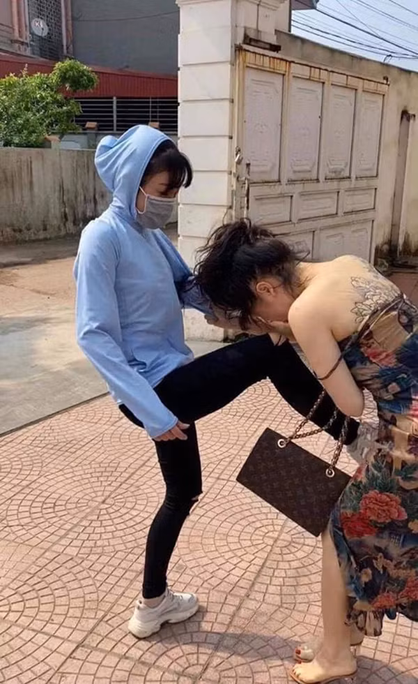 Cô bồ ôm chặt nhân tình mặc người vợ đánh tới tấp. Ảnh cắt từ clip.