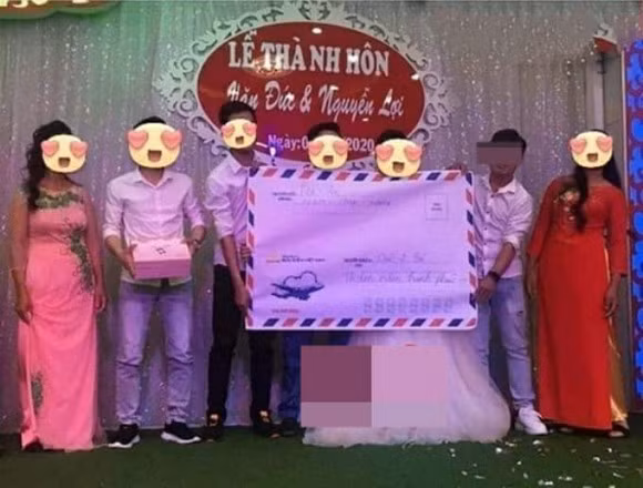 Mua một cái phong bì vài ngàn đồng rồi bỏ tiền mừng và đưa tận tay cô dâu chú rể thì ai mà chẳng làm được. Nhưng kỳ công chuẩn bị cả một phong bao cỡ lớn thế này, thực sự không phải chuyện đơn giản.