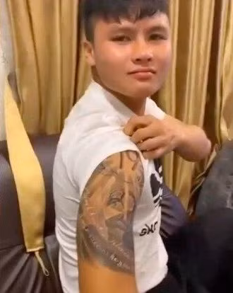 Theo đó, hình xăm mới của tiền vệ Quang Hải là một bức tranh được lồng ghép nhiều biểu tượng vào nhau gồm số 19 (số áo của Quang Hải), biểu tượng ngôi sao vàng, trái bóng và hai dòng chữ khá dài.