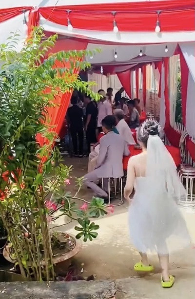 Nếu gặp trường hợp này có lẽ sẽ có không ít người hẹn shipper quay lại vào một hôm khác vì không tiện để lấy hàng. Thế nhưng cô dâu trong clip lại quyết định mặc nguyên bộ váy cưới ra nhận đồ trước khi đổi địa chỉ giao hàng về nhà chồng.