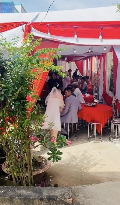 Điều khiến người xem cảm thấy hài hước hơn là cô dâu còn đang đi một đôi dép lê màu xanh nõn chuối chẳng ăn nhập gì với bộ váy.