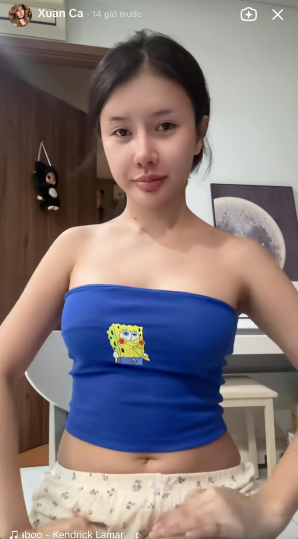 Xuất hiện trong clip, cô nàng TikToker diện chiếc áo quây màu xanh và trong khung cảnh tại nhà.