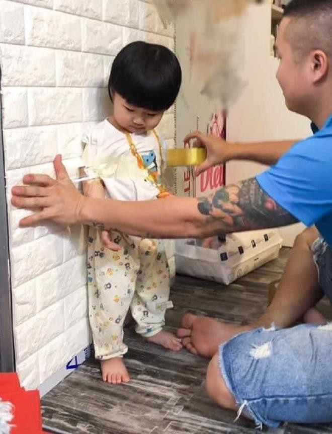 Thì vì trông con, người đàn ông này dùng băng dính dán con vào tường.