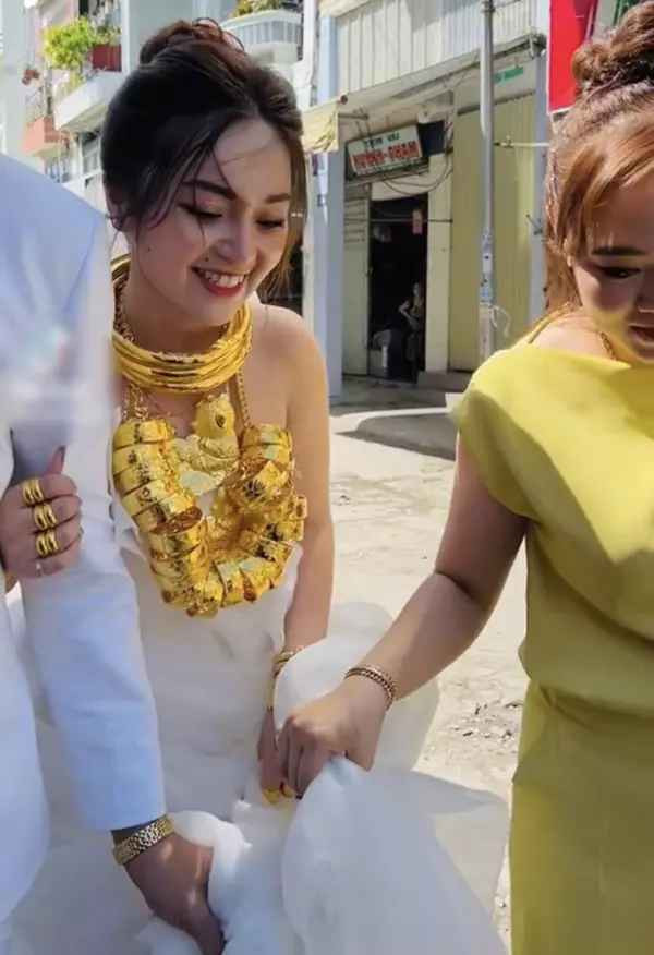 Khoảnh khắc do TikTok T.F chia sẻ lại cho thấy, cô dâu miền Tây được người thân đeo cho rất nhiều kiềng vàng, nhẫn, và đặc biệt là chiếc dây chuyền xâu vô số lắc tay.