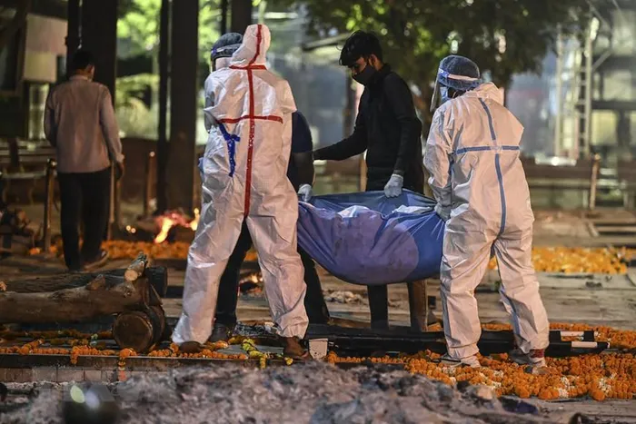 Nhân viên y tế chuyển thi thể bệnh nhân COVID-19 tới nhà hỏa táng Nigambodh Ghat ở New Delhi, Ấn Độ ngày 22/4/2021. (Ảnh: AFP/TTXVN)
