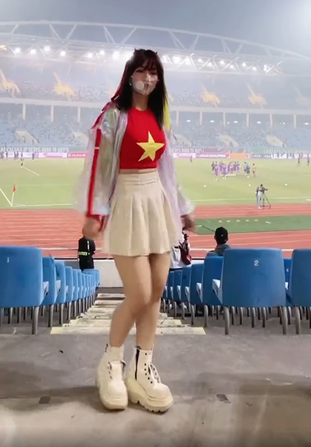 Thời tiết tối qua khá lạnh, song Lê Bống chỉ mặc chiếc áo phông đỏ in hình quốc kỳ Việt Nam, bên ngoài khoác chiếc áo mỏng trong suốt. Cô cũng đeo khẩu trang trong suốt để "tông xuyệt tông" với bộ trang phục.