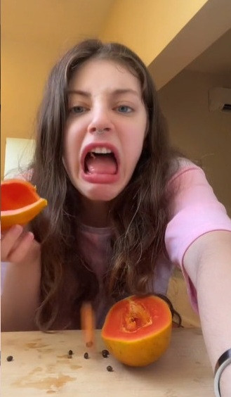 Tiếp đến, cô thử phần ruột màu cam với gương mặt hài lòng. Những tưởng chỉ đến đây thôi, nhưng cô gái trẻ này lại ăn nốt cả phần vỏ để rồi nhăn mặt vì đắng.