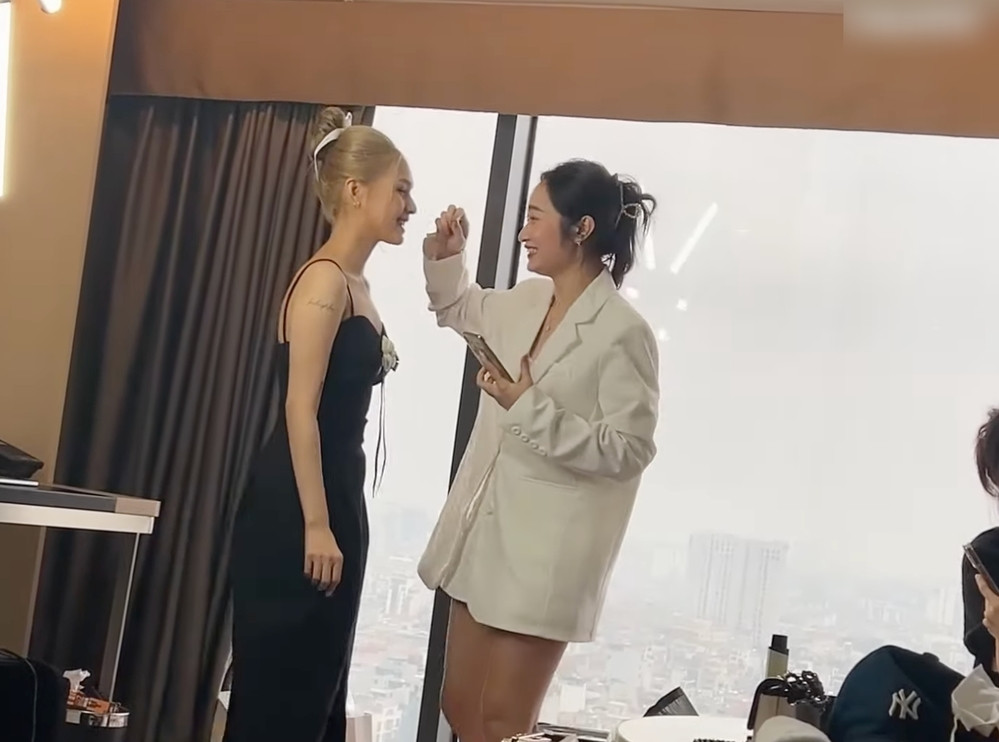 Hậu trường Xoài Non "lên đồ" chuẩn bị để dự tiệc cưới của bạn thân cũng được Linh Ngọc Đàm ghi lại toàn bộ. Bà xã Xemesis chọn trang phục có thiết kế đơn giản là một chiếc váy đen để lộ bờ mai thanh mảnh, tà váy được xẻ cao.