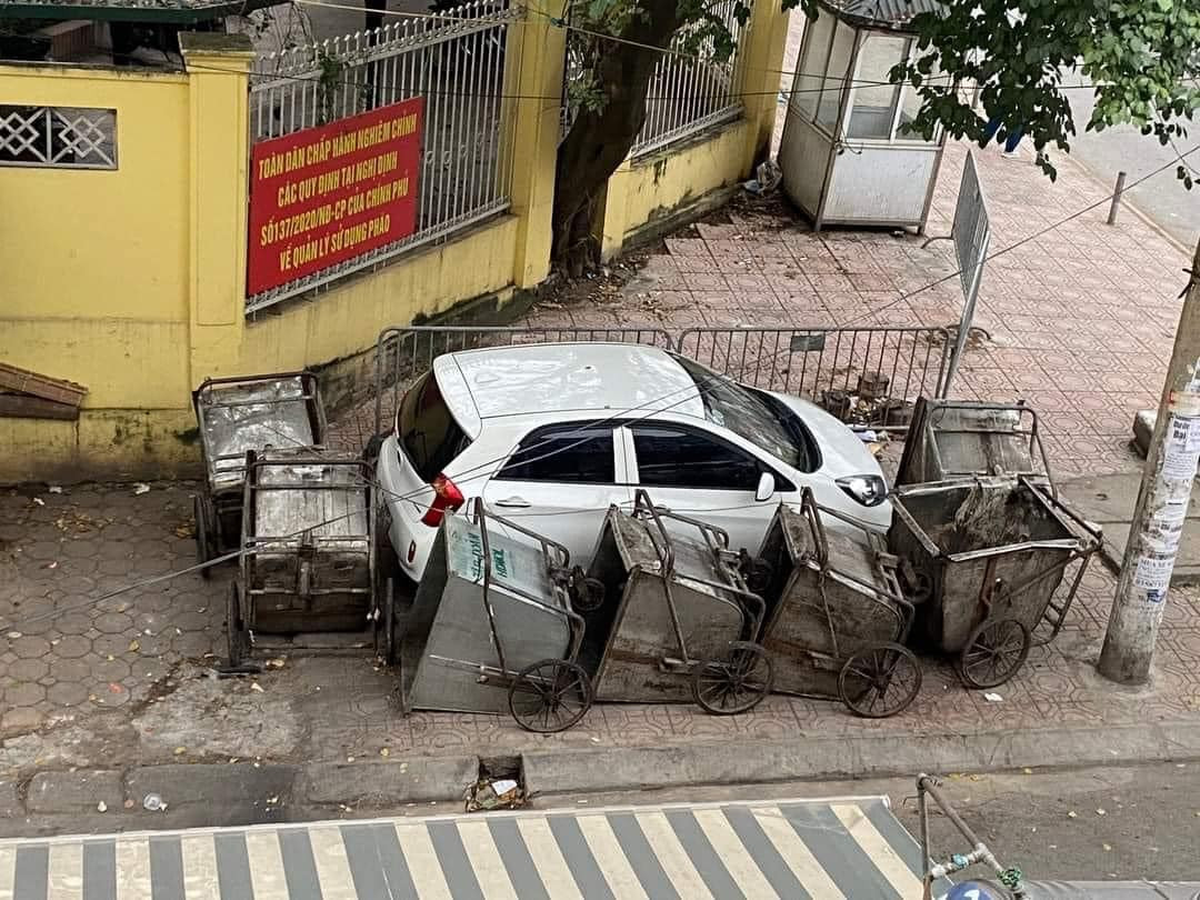 Khi trở lại xe, tài xế chứng kiến cảnh chiếc xe màu trắng của mình đã bị gần chục chiếc xe rác bao vây xung quanh.