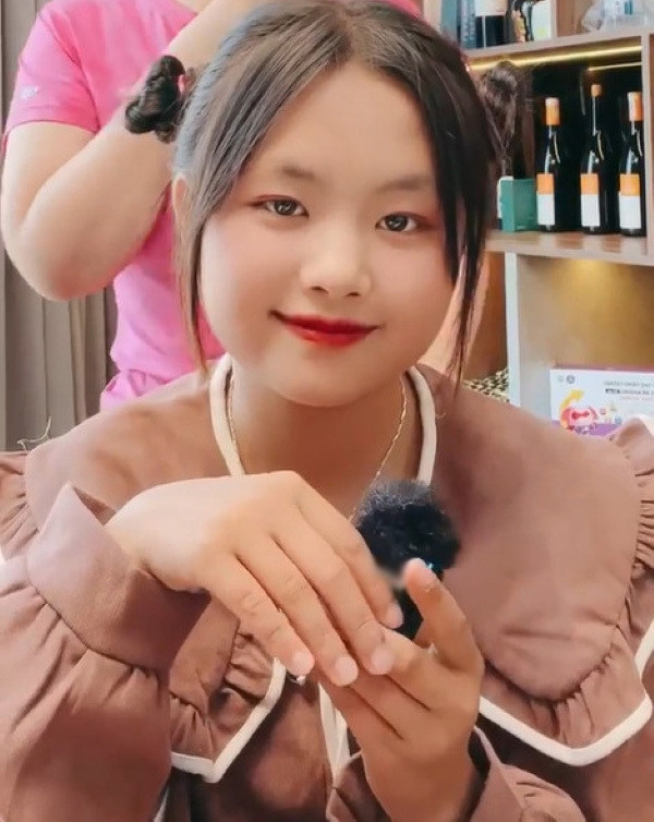 Còn về phần mái tóc hơi "dị", thực chất đó chỉ là tóc giả. Sau khi bỏ bộ tóc cam đi, Phúng Phính lại trở lại với vẻ ngoài đáng yêu, xinh xắn.