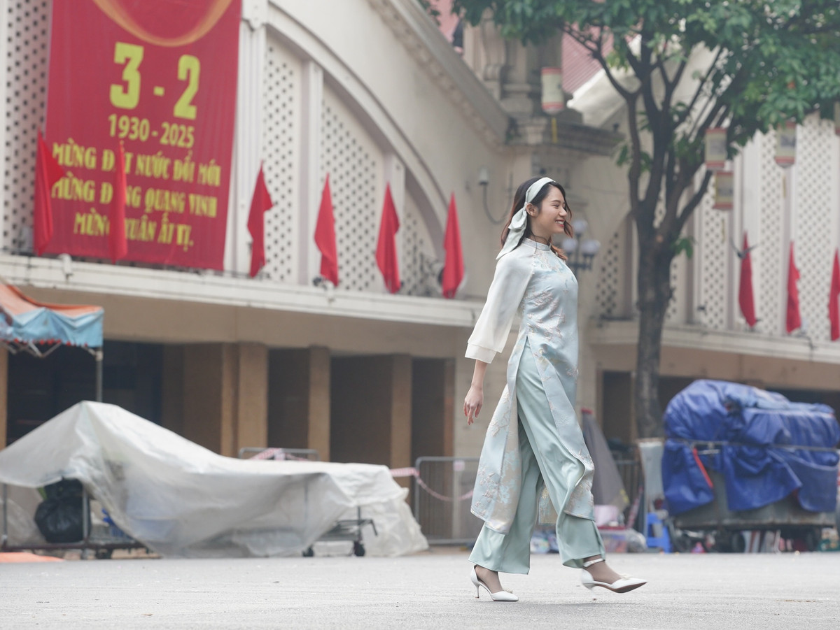 Thiếu nữ Hà Thành diện áo dài sải bước trước cổng chợ Đồng Xuân.