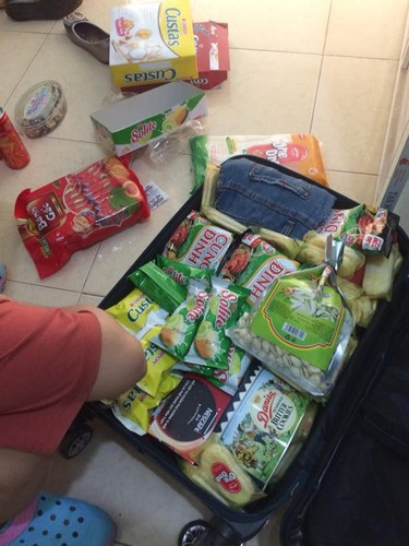 Một chiếc vali với đầy đủ bánh kẹo, mì tôm... được bố mẹ gói gém cho con lên thành phố sau dịp nghỉ Tết.