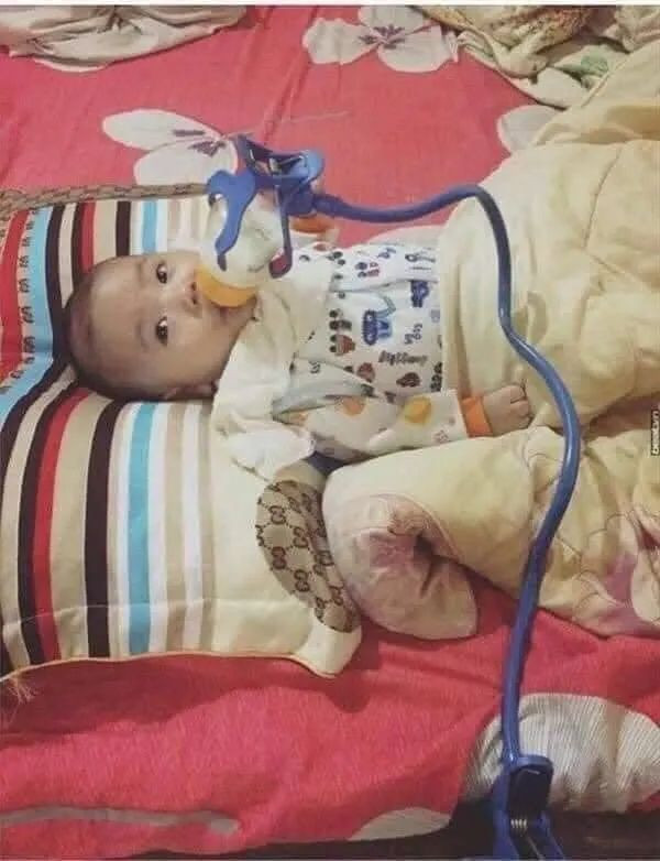 Thay vì tự tay cầm bình sữa để cho con uống thì ông chồng đã vận dụng các công cụ hỗ trợ để làm việc này.