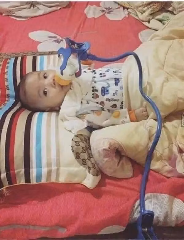 Thay vì tự tay cầm bình sữa để cho con uống thì ông chồng đã vận dụng các công cụ hỗ trợ để làm việc này.