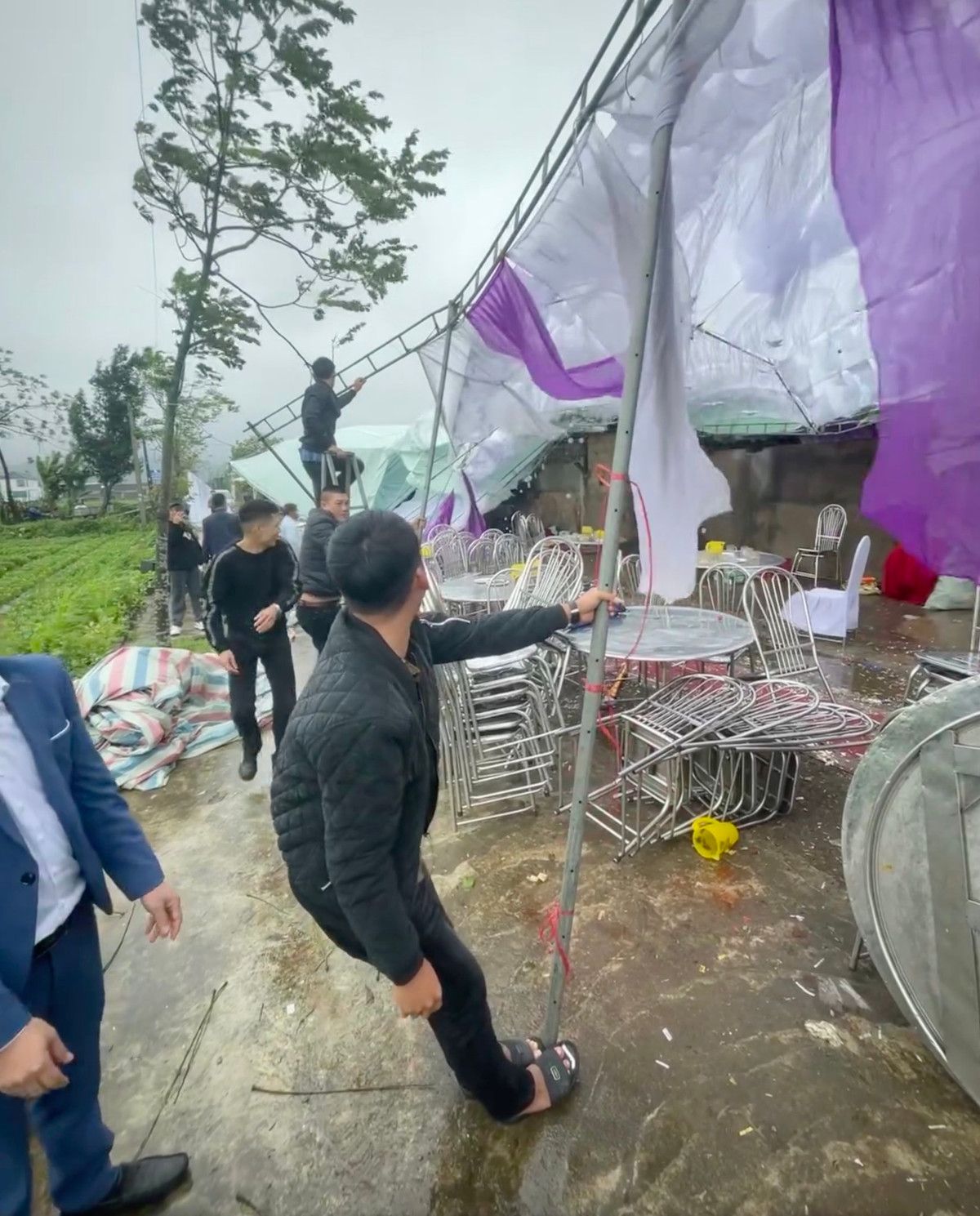 Đang ăn cỗ nhưng lỡ gió to phải đứng dậy giữ rạp cưới.