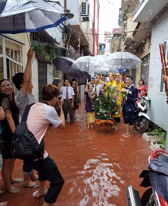 Đoàn bê tráp của đám cưới ngày mưa thay vì đi những đôi giày bóng loáng thì lựa chọn tối ưu đó là những đôi dép lê.