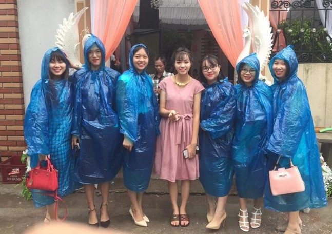 Cô dâu cùng hội bạn thân trong ngày cưới và đồng phục là chiếc áo mưa xanh.
