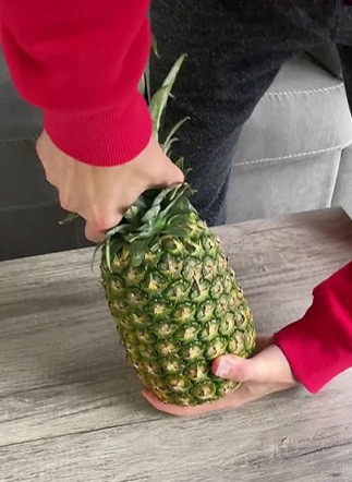 Đầu tiên, xoay phần đầu quả dứa để loại bỏ nó trước khi dựng đứng nó và đập xuống đất với lực vừa phải, tránh ảnh hưởng đến ruột trái cây, vừa đập vừa xoay để áp lực được lan tỏa đều ở phần đáy.