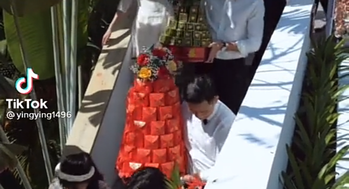 Cụ thể, một tài khoản TikTok có tên Ying Ying đã đăng tải đoạn video chia sẻ hình ảnh về buổi đám cưới sang trọng của cặp cô dâu chú rể. Mở đầu video có thể thấy hôn lễ được tổ chức long trọng, dàn bưng tráp và lễ vật nối thành hàng dài.