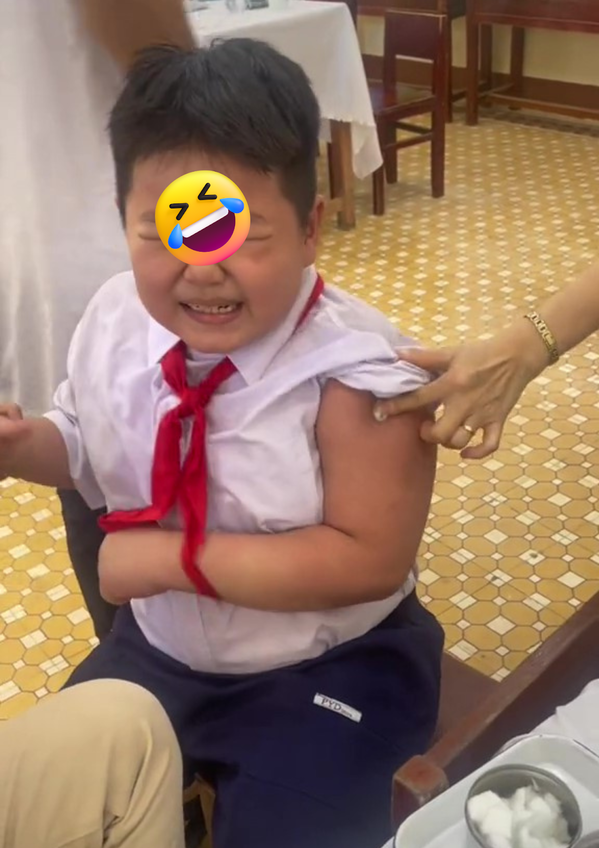 Sau khi đã giữ được cậu bé ổn định, cô y tá nhanh chóng tiêm vắc-xin cho cậu bé.