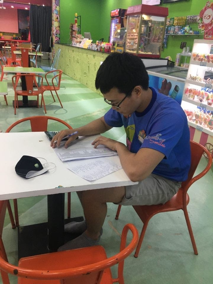 Nam sinh tranh thủ giờ nghỉ giải lao giữa ca làm thêm để học bài. (Ảnh: Minh Chiến)
