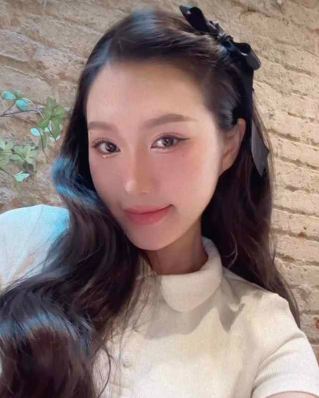 Doãn Hải My tạo kiểu tóc điệu đà, dùng chiếc nơ mềm mại làm điểm nhấn, gương mặt trang điểm theo phong cách nhẹ nhàng.