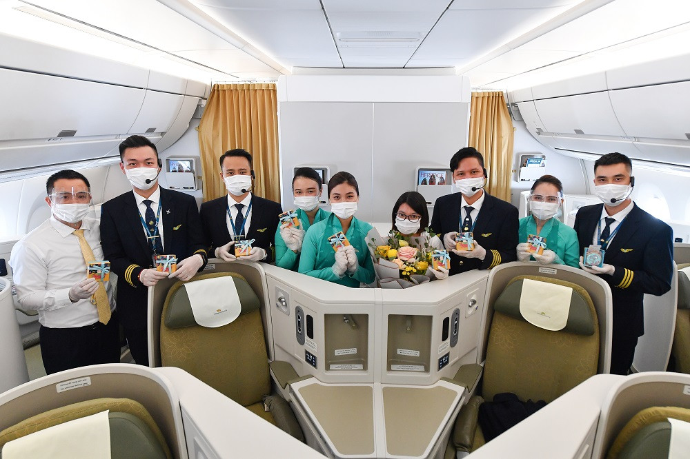 Đại diện tổ phi công thay mặt chuyến bay tặng quà cho đại diện một khách hàng nữ.