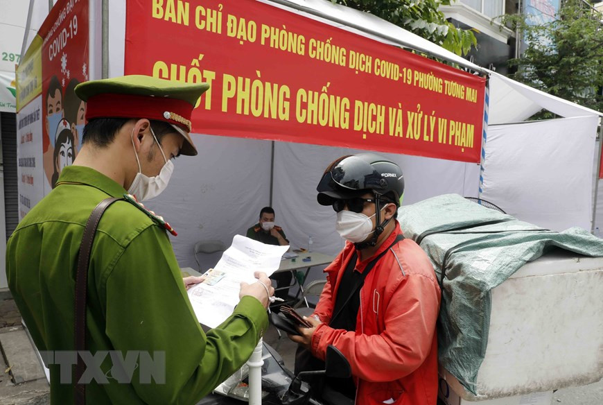 Công an Hà Nội đã lập chốt kiểm soát COVID-19 tại nhiều tuyến phố trung tâm Thủ đô để kiểm tra, xử phạt những trường hợp người dân ra ngoài không có nhu cầu thiết yếu, đi làm không có giấy tờ tùy thân, giấy xác nhận đi làm có đóng dấu của cơ quan, đơn vị... (Ảnh: Trần Việt/TTXVN)