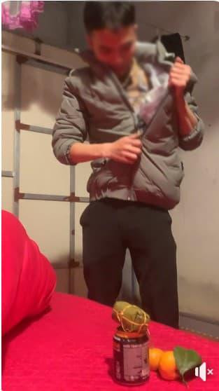 Đáng chú ý là trời nắng nóng nhưng người chồng mặc áo khoác và giấu cam, nước ngọt, giò và túi tôm để đưa về cho vợ.