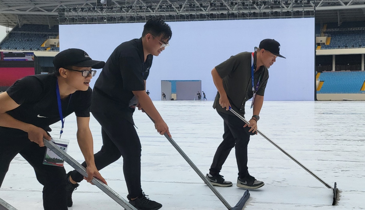 Không chỉ có tình nguyện viên, chính tay nhạc sĩ Huy Tuấn, người sáng tác ca khúc chính thức cho SEA Games 31 cũng sắn tay lên để làm khô sân khấu chính.