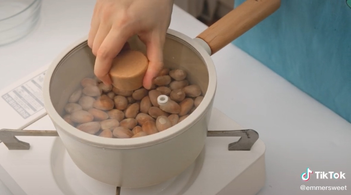 Sau khi tách múi, TikToker giữ lại hạt, rửa sạch và sau đó luộc lên trên bếp.