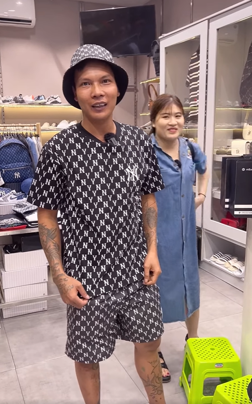 Khi hai vợ chồng đứng xem giá áo khoác, anh lại khẳng định lần nữa, kèm theo một câu bông đùa quen thuộc: “Mùa hè em có lấy áo ấm em mặc không? Ý là anh mua cho em, anh vào đây là để anh mua cho em, tặng cho em, em lấy đi”.