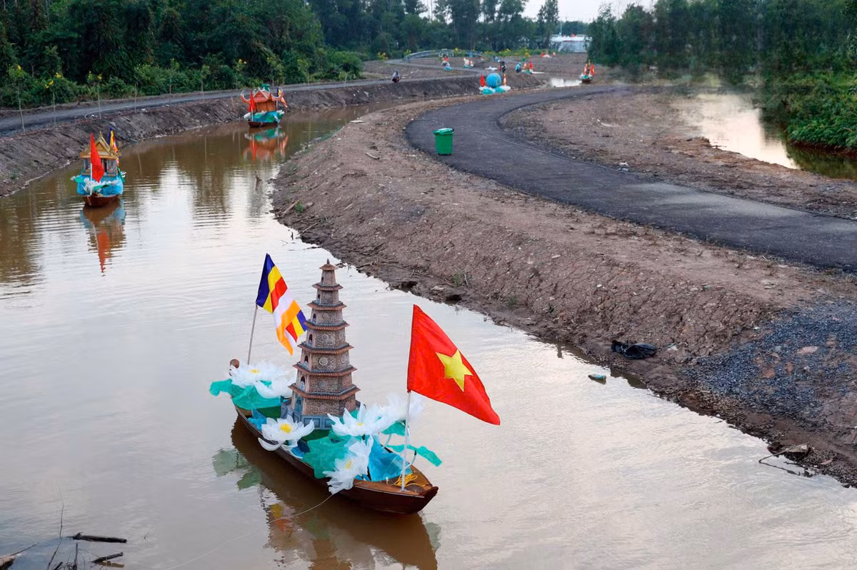 Phật tử trang trí chiếc thuyền với hình tượng ngôi chùa xung quanh hoa sen.